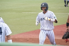 満塁本塁打を放ち、笑顔で生還する仙台大・辻本倫太郎